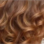 Cabello rizado y brillante en tonos dorados celebra la belleza natural